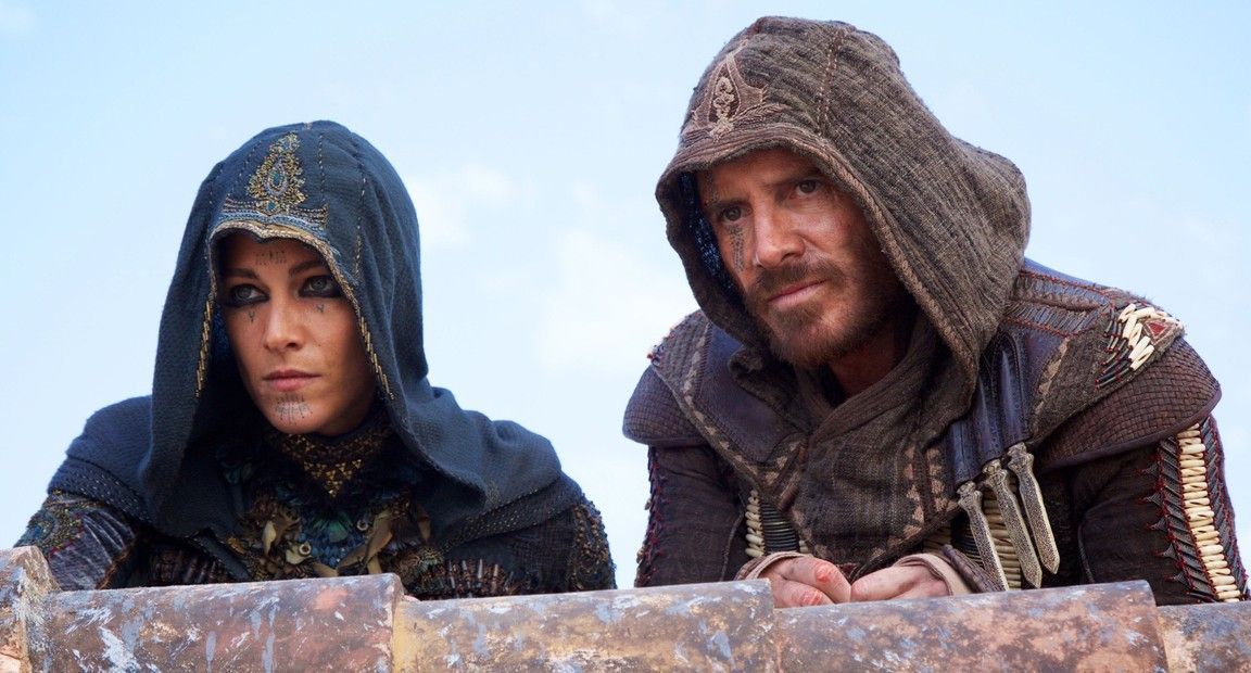 Two people in hooded outfits looking intently, on a rooftop.