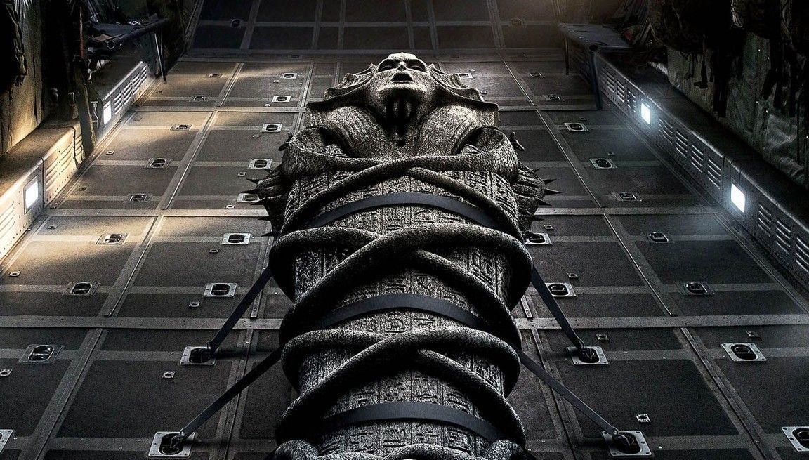 Stone sarcophagus, bound with dark straps, inside a dimly lit industrial space.