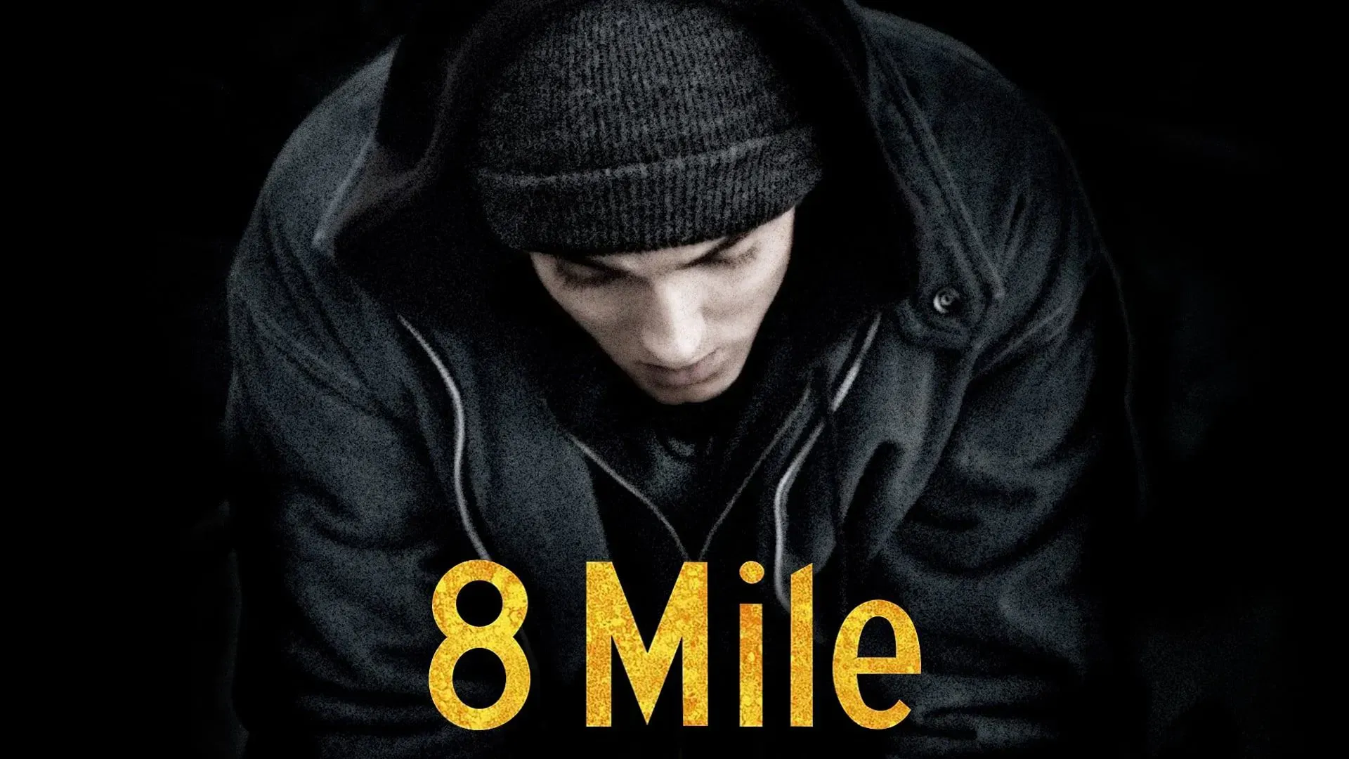 Eminem from 8 Mile movie. Dark image of a man in a hoodie with the movie title in gold.