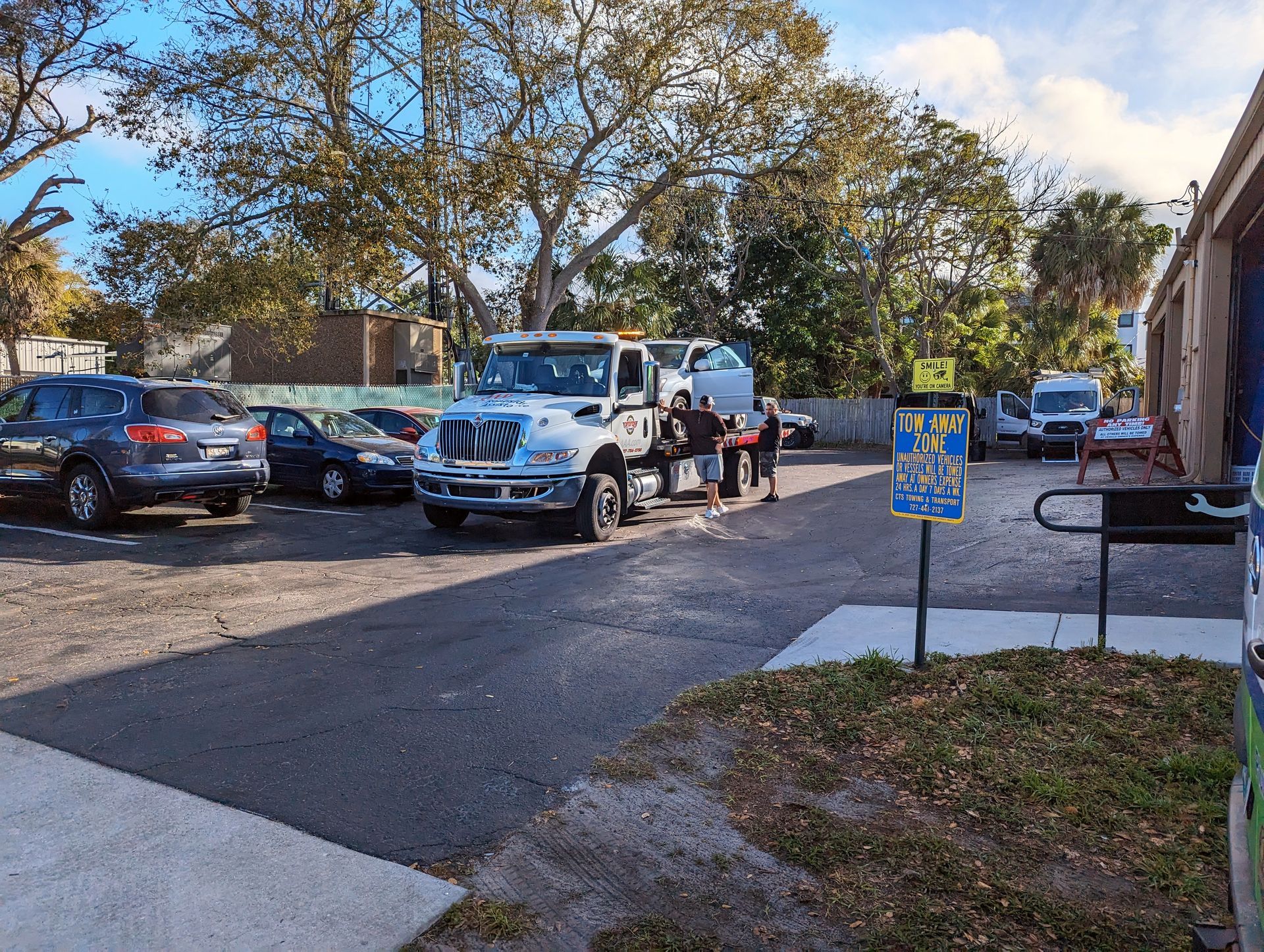 A tow truck loading a car in a parking lot | Dunedin Garage