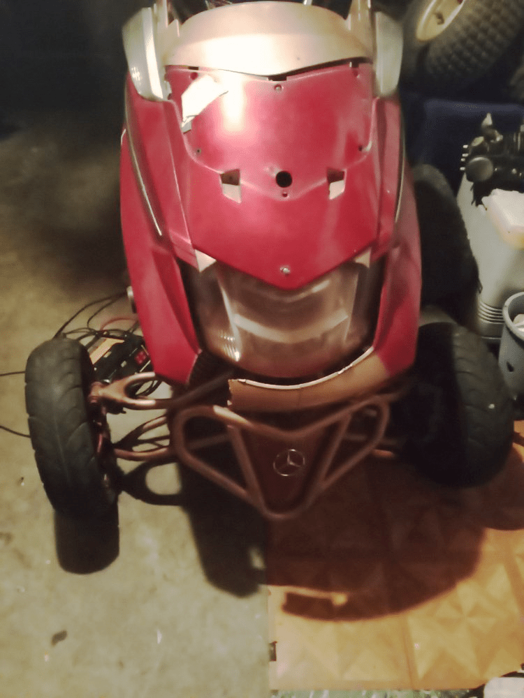 Red and gold custom ATV-style lawnmower, in a garage.