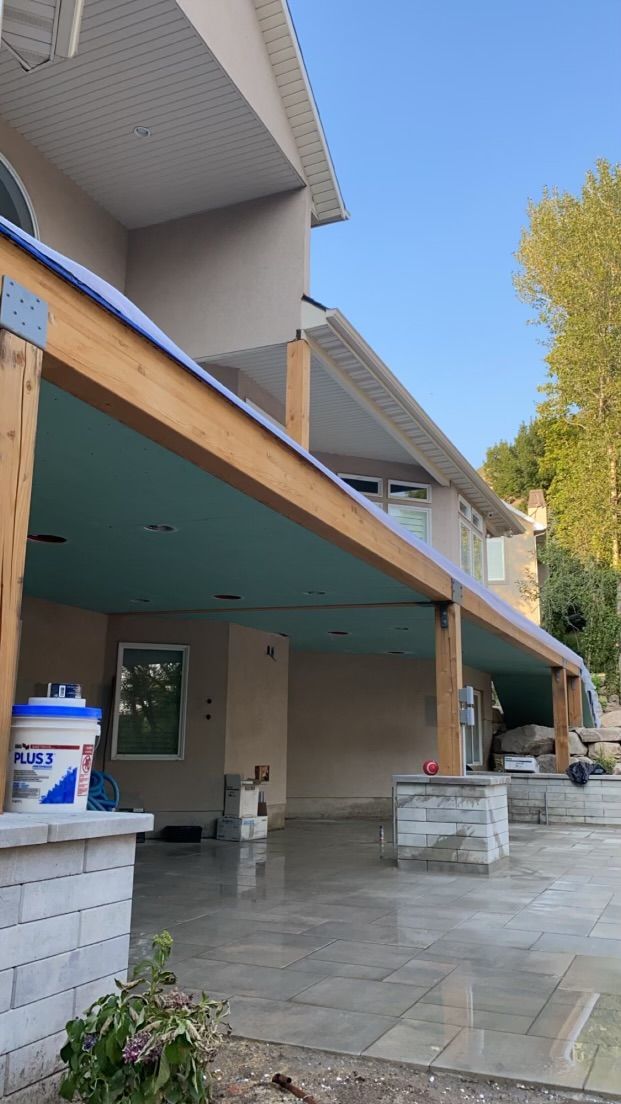 A wooden deck with chairs and a table under a pergola.