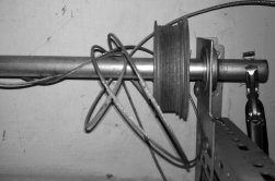 A black and white photo of a garage door opener with wires hanging off of it.