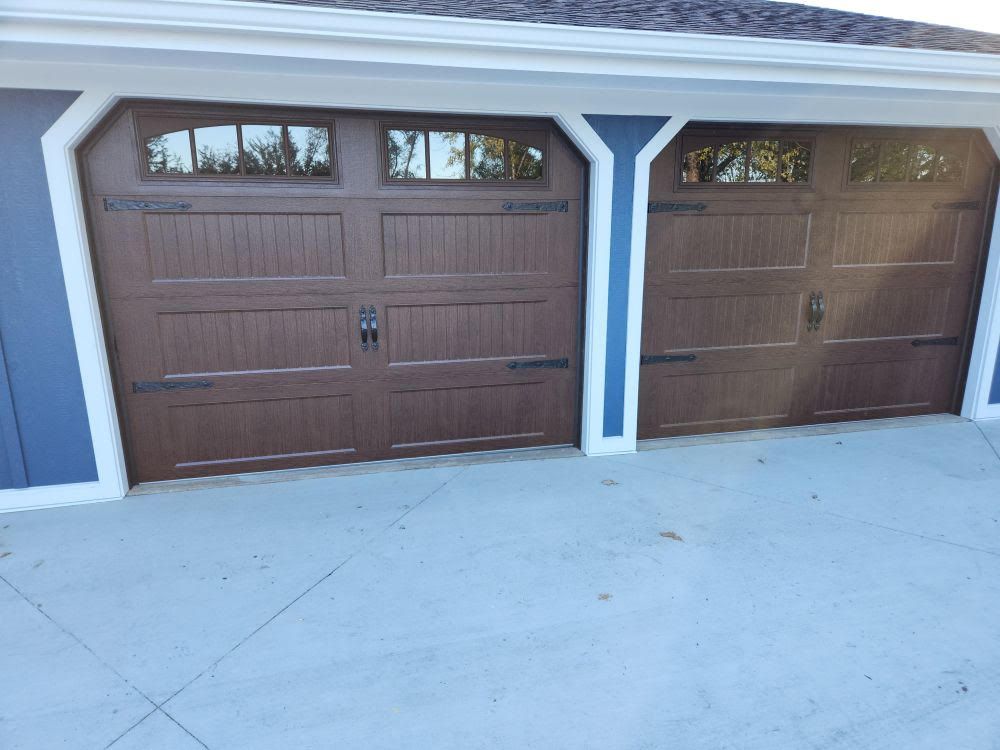 A garage with two brown garage doors and a white trim