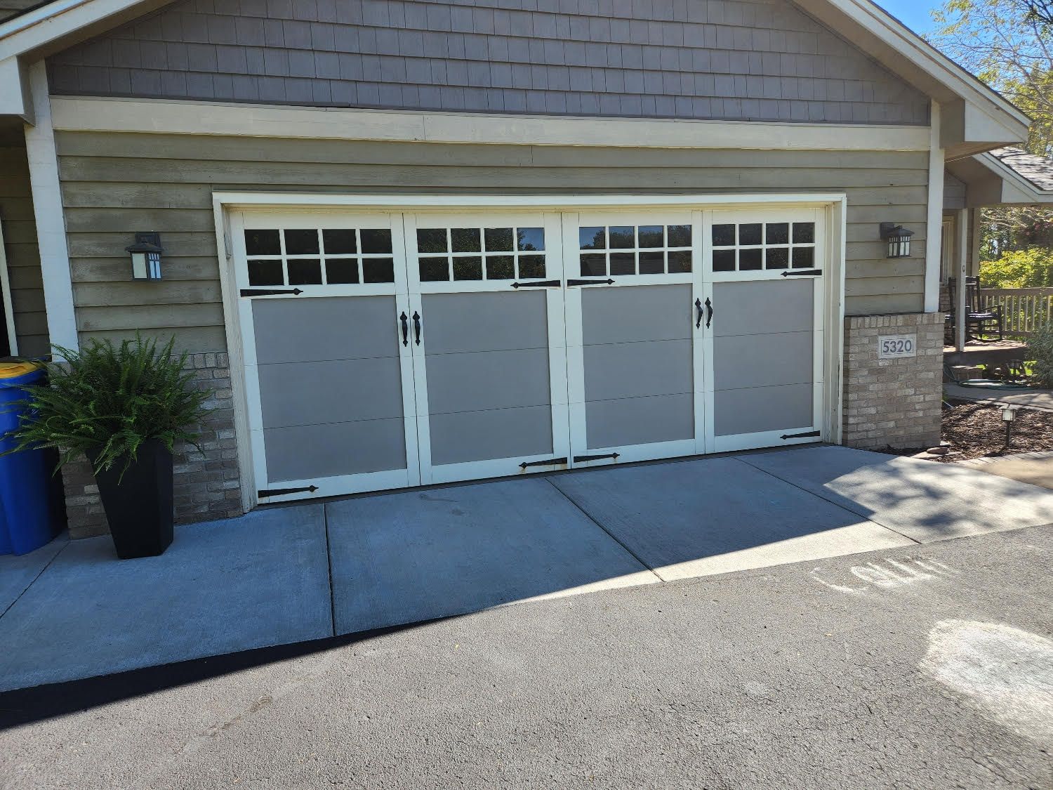 A large garage door is sitting on the side of a house.