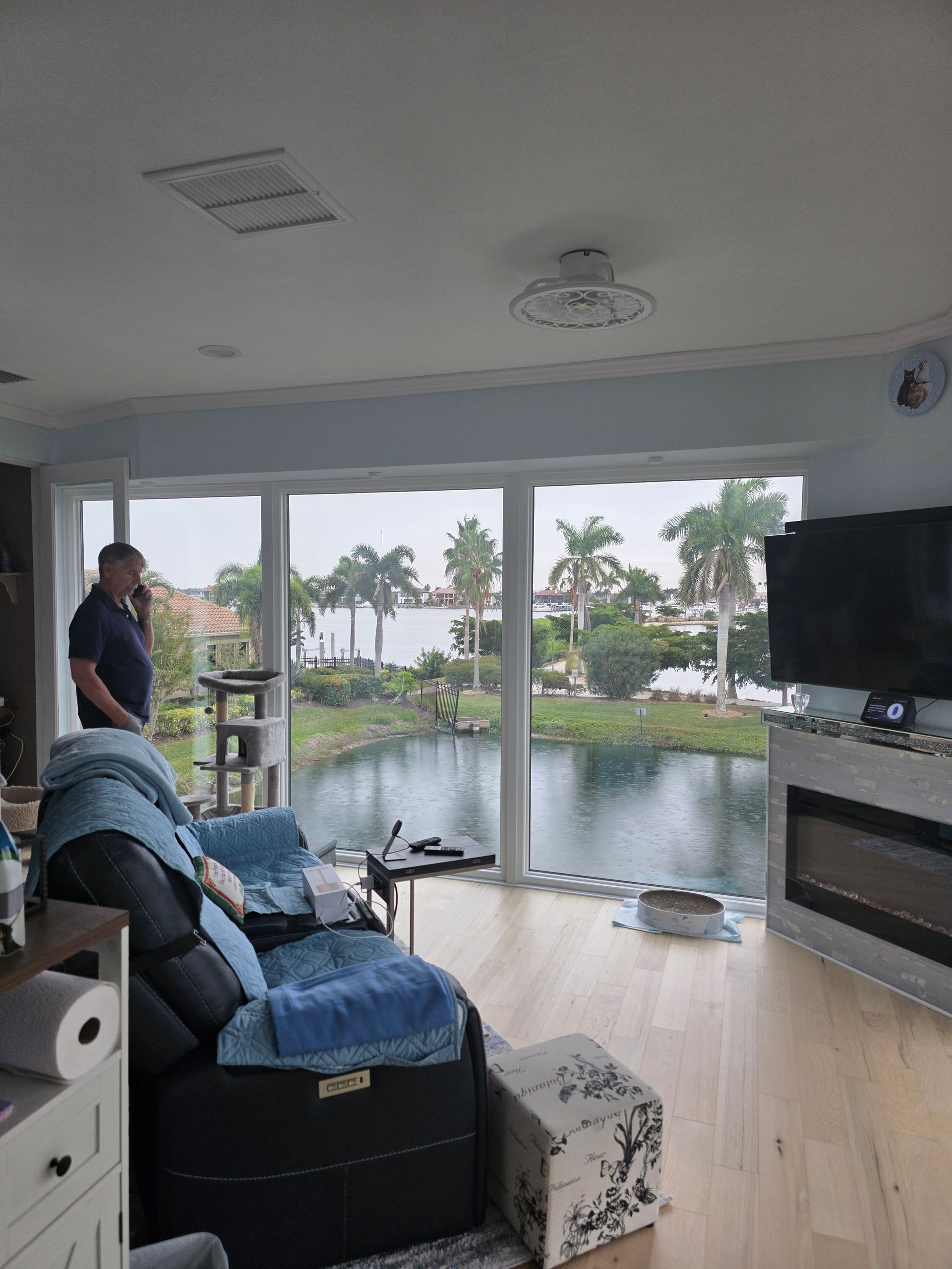 Person installing a silver door handle on a light wood door, wearing blue overalls.