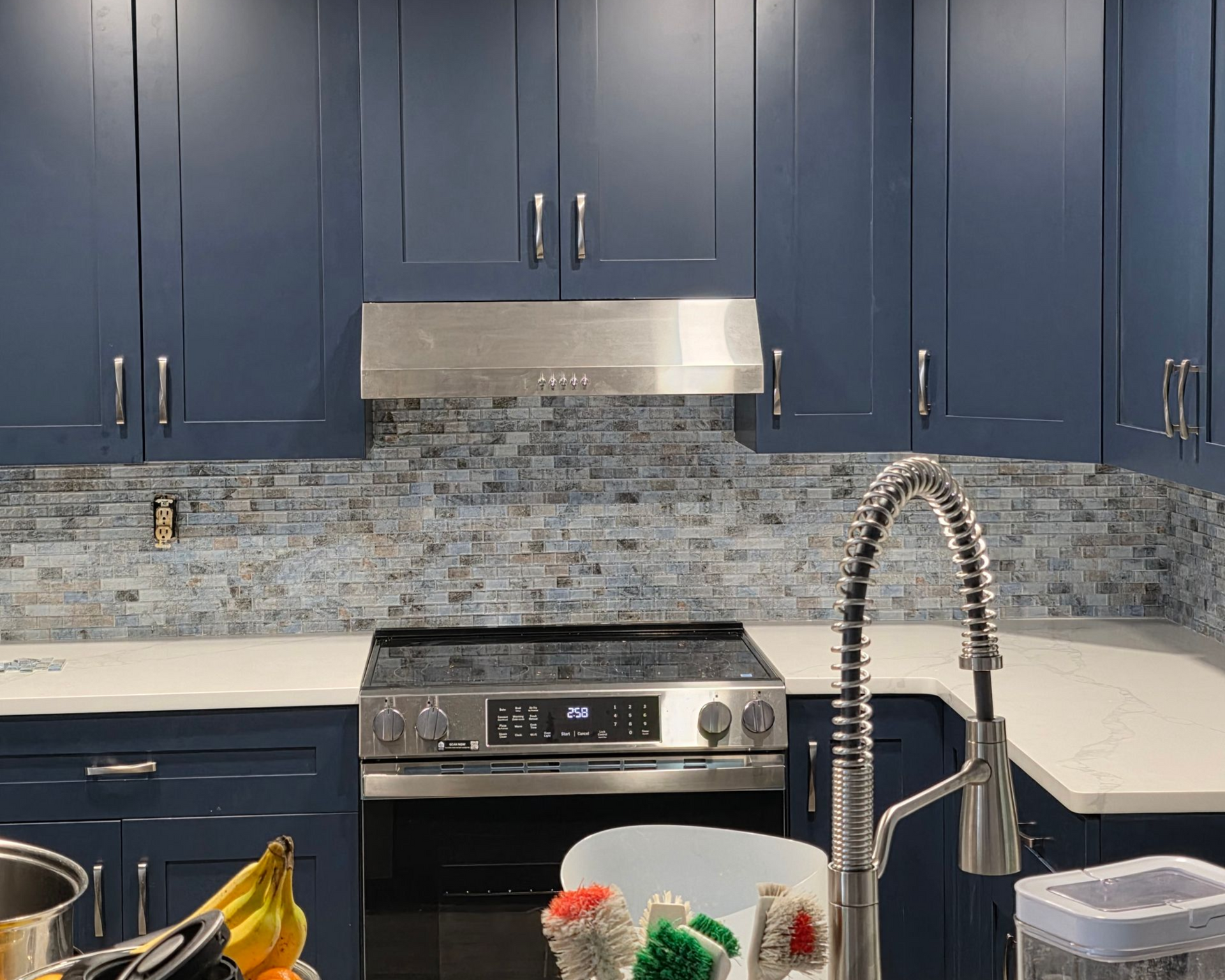 Person using a yellow drill to install a black door handle on a black door.