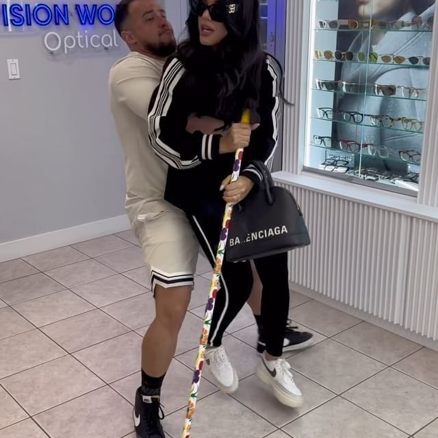 A man carrying a woman with a balenciaga bag