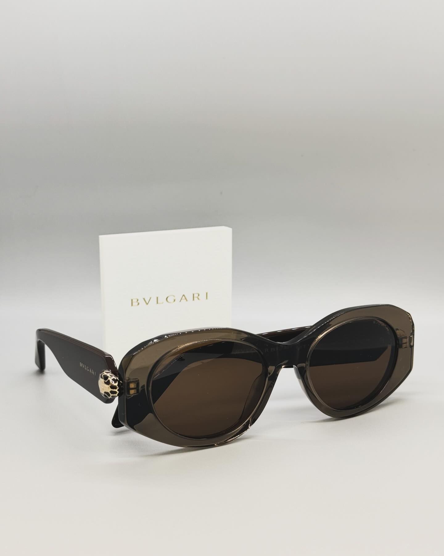 A pair of bvlgari sunglasses sitting on top of a white surface.
