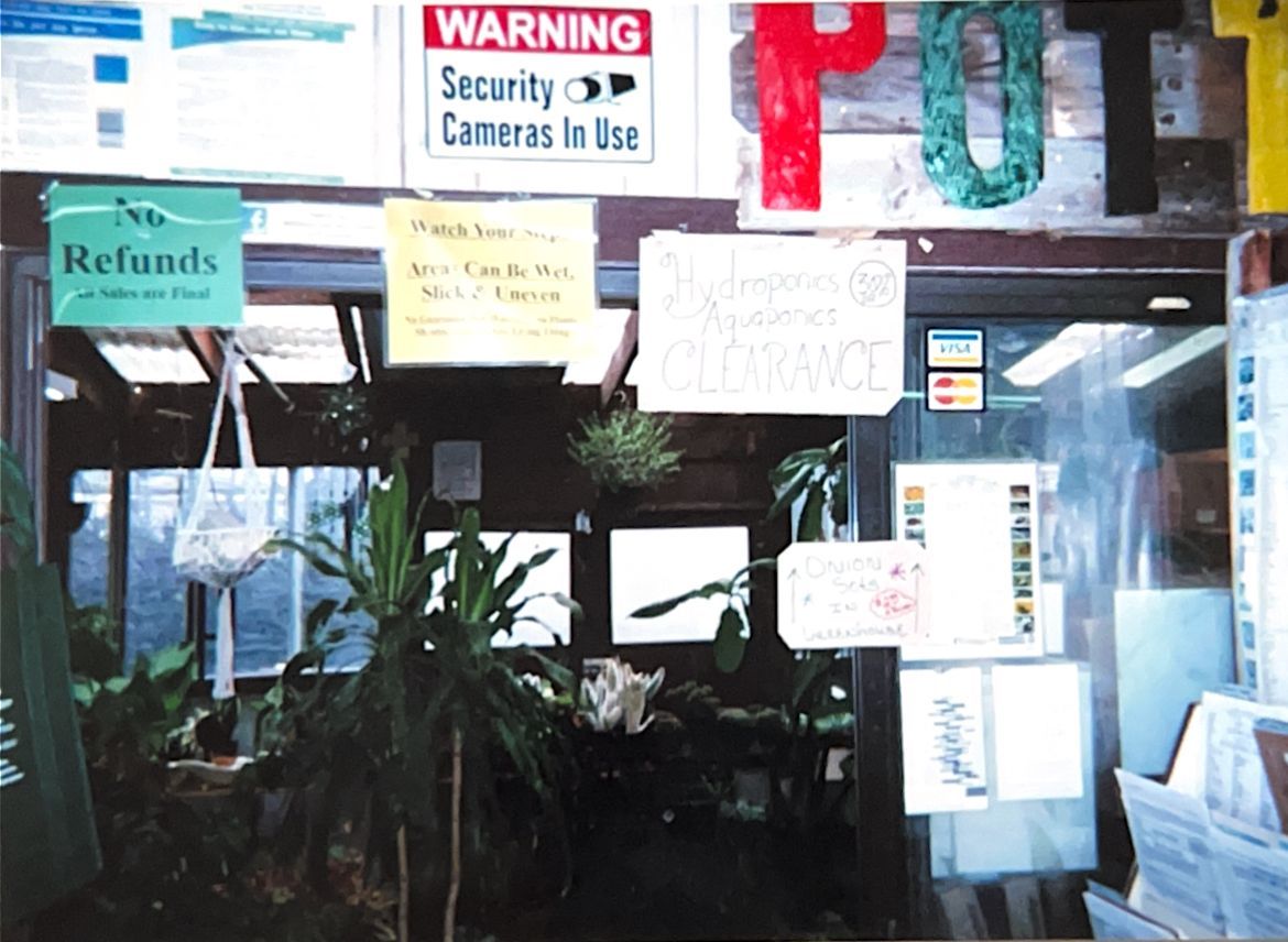 Storefront with multiple warning and refund signs on the windows and doors.