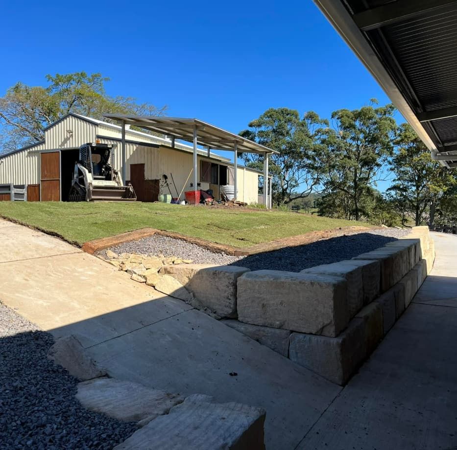 A Large White Building Is Sitting On Top Of A Grassy Hill — Equine Stable Solutions In Brisbane, QLD