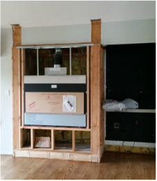 A wooden entertainment center is being built in a living room