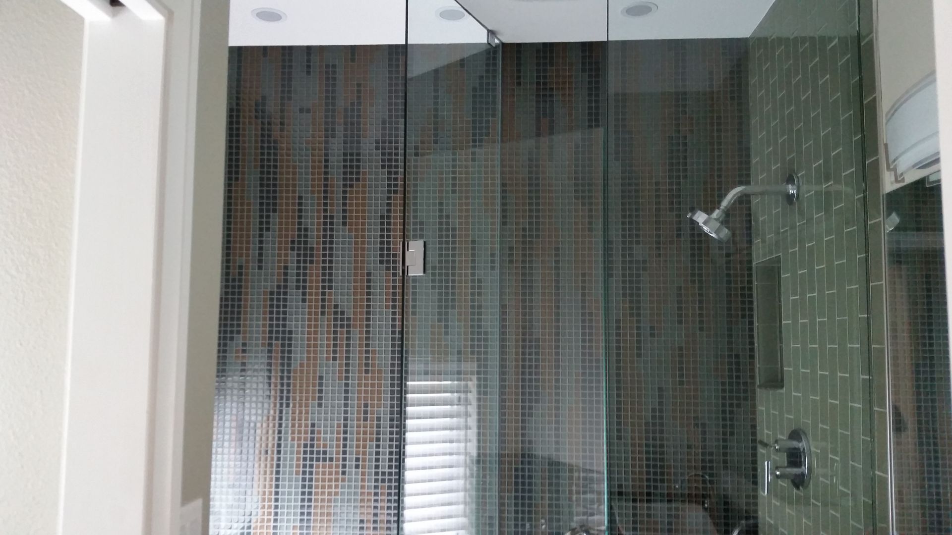 A bathroom with a walk in shower and a mirror.