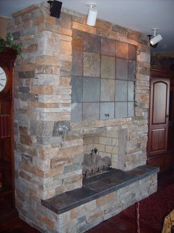 A stone fireplace in a living room next to a clock