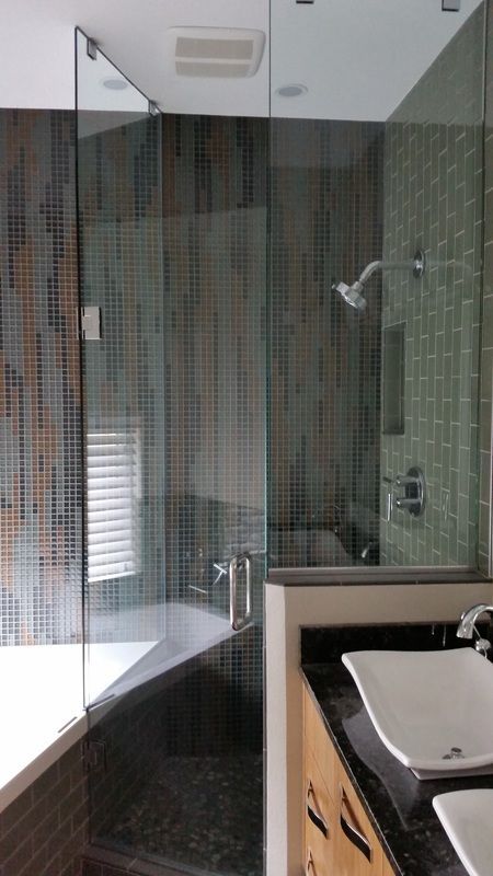 A bathroom with two sinks and a walk in shower