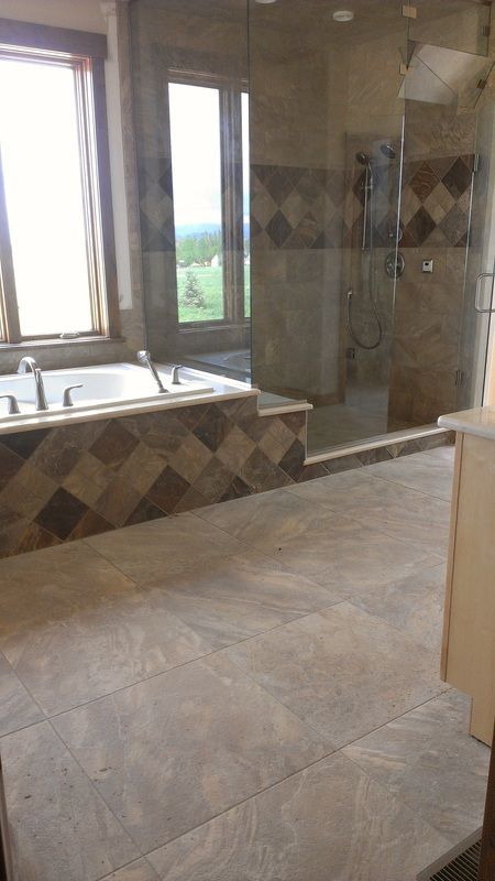 A bathroom with a tub , shower and window.