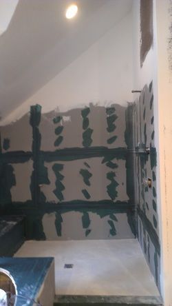 A bathroom with a walk in shower under construction.