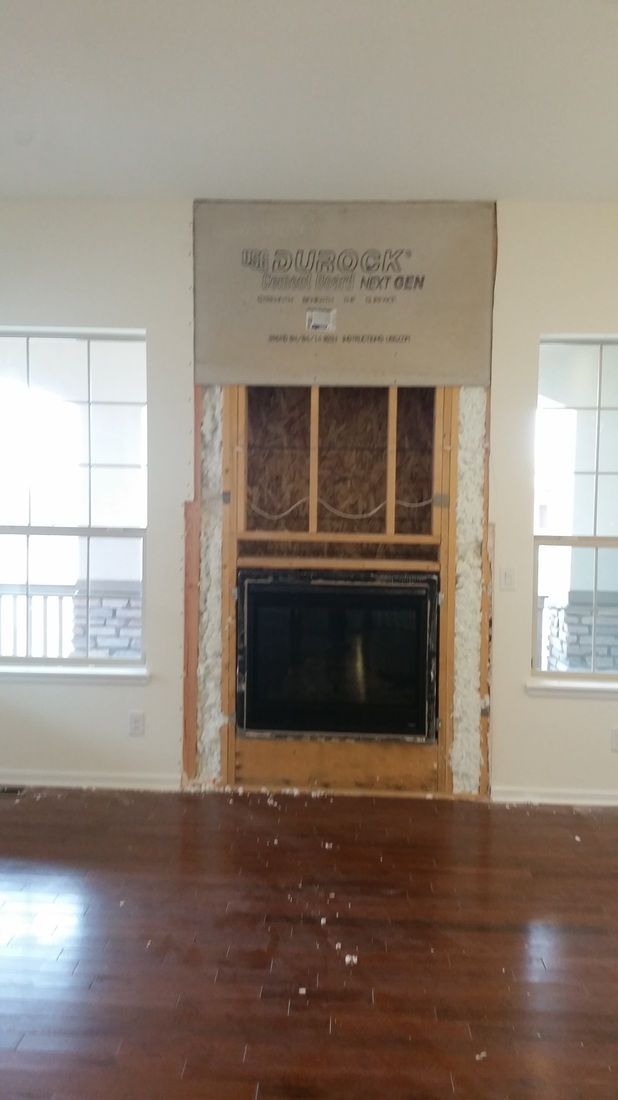 An empty living room with a fireplace in the middle of it