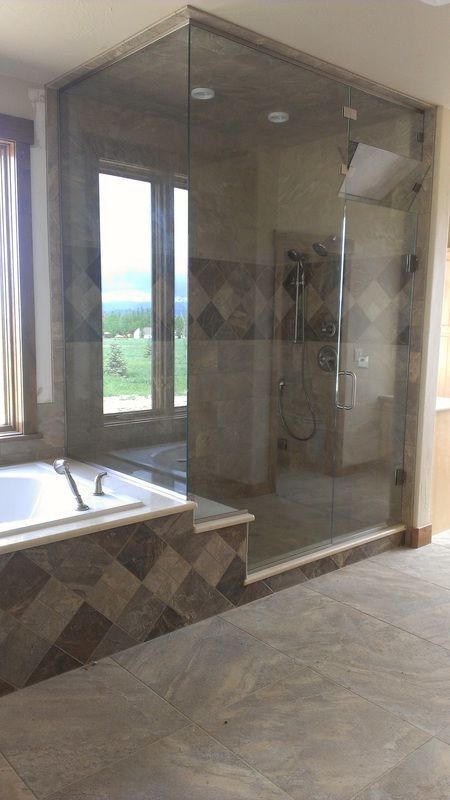 A bathroom with a tub , shower , and window.