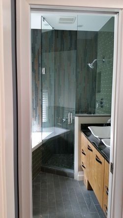 A bathroom with a glass shower door and a sink.