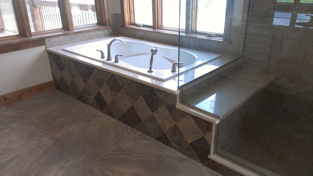 A bathroom with a jacuzzi tub and a walk in shower.