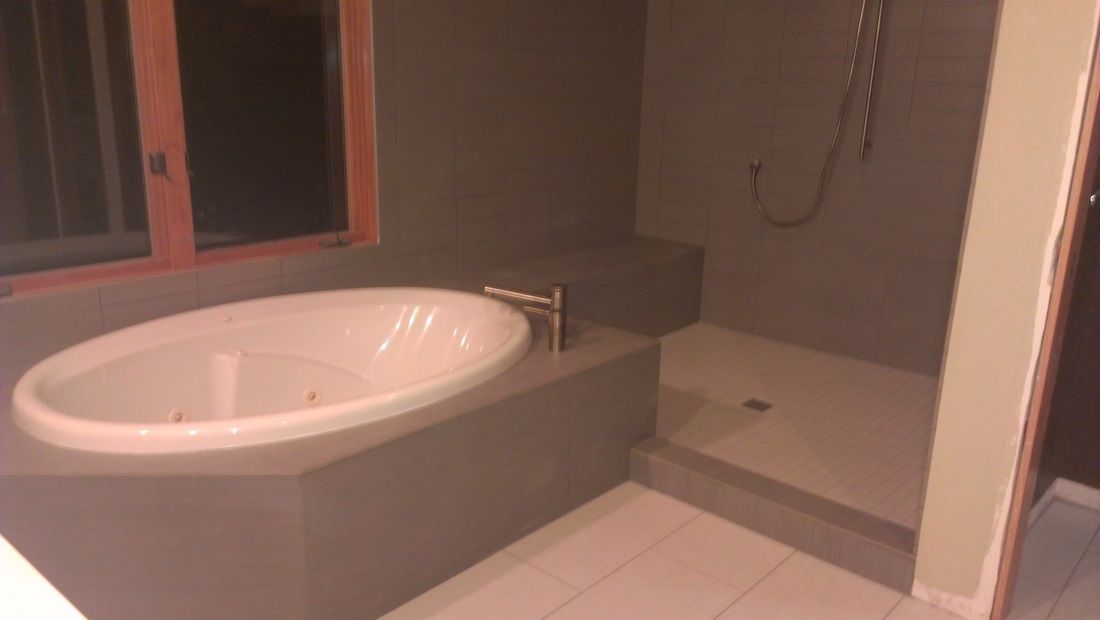 A bathroom with a bathtub and a shower.