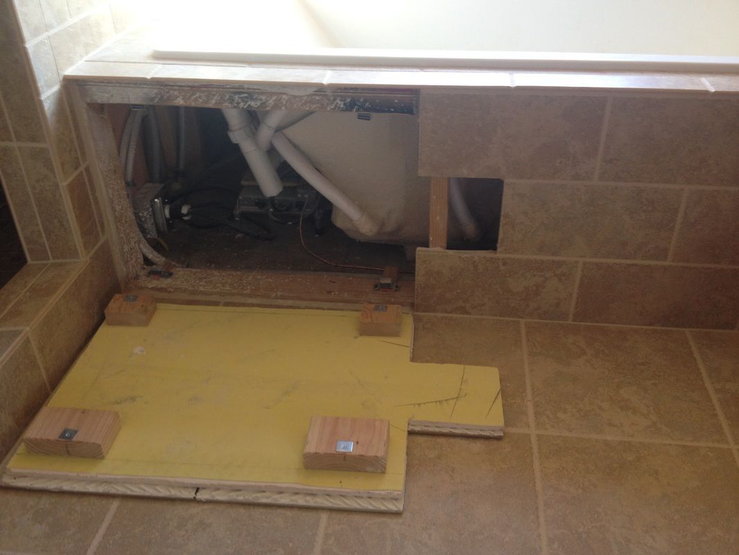 A bathtub is being built in a bathroom and there is a hole in the wall.