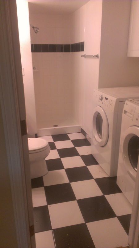 A bathroom with a checkered floor and a toilet
