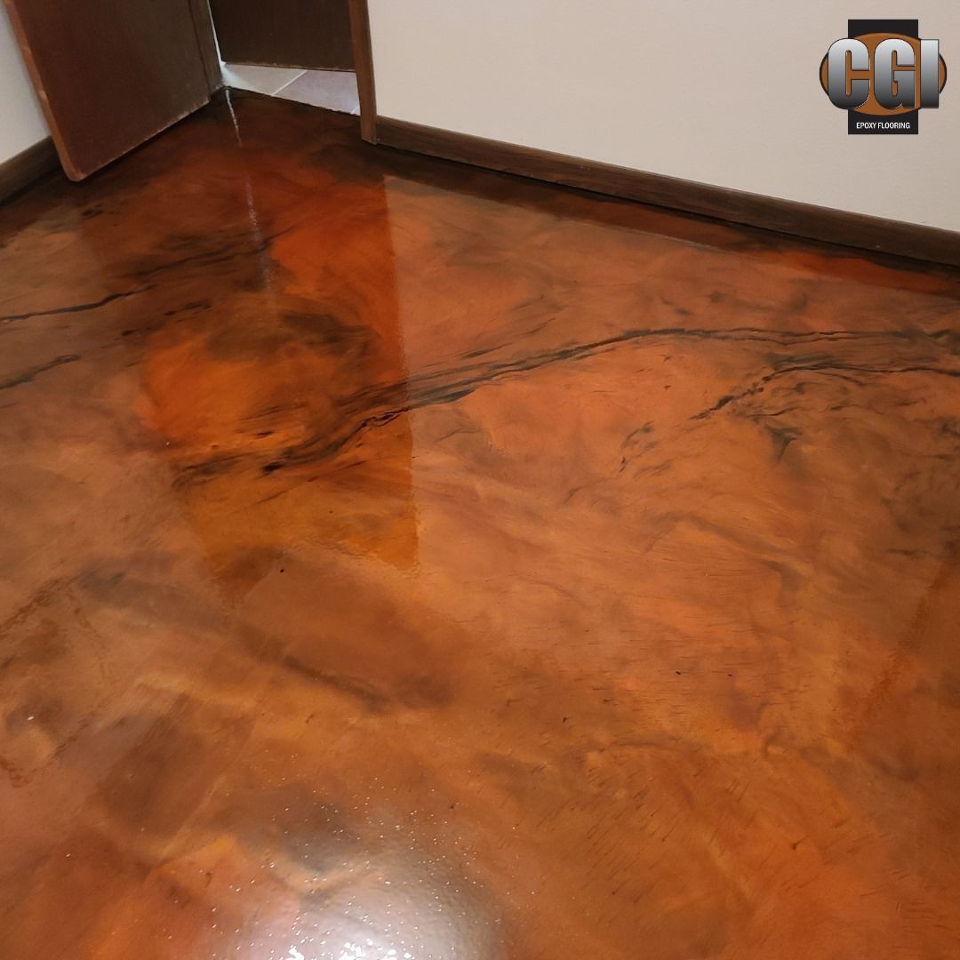 Polished orange-brown concrete floor with reflective patches and a dark crack near a wall corner.