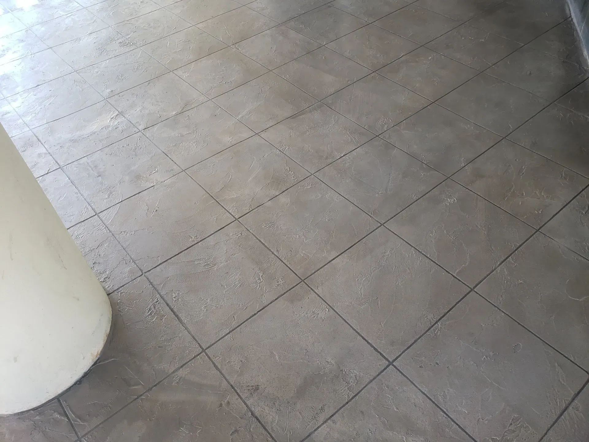 Light gray tiled floor with a white column on the left