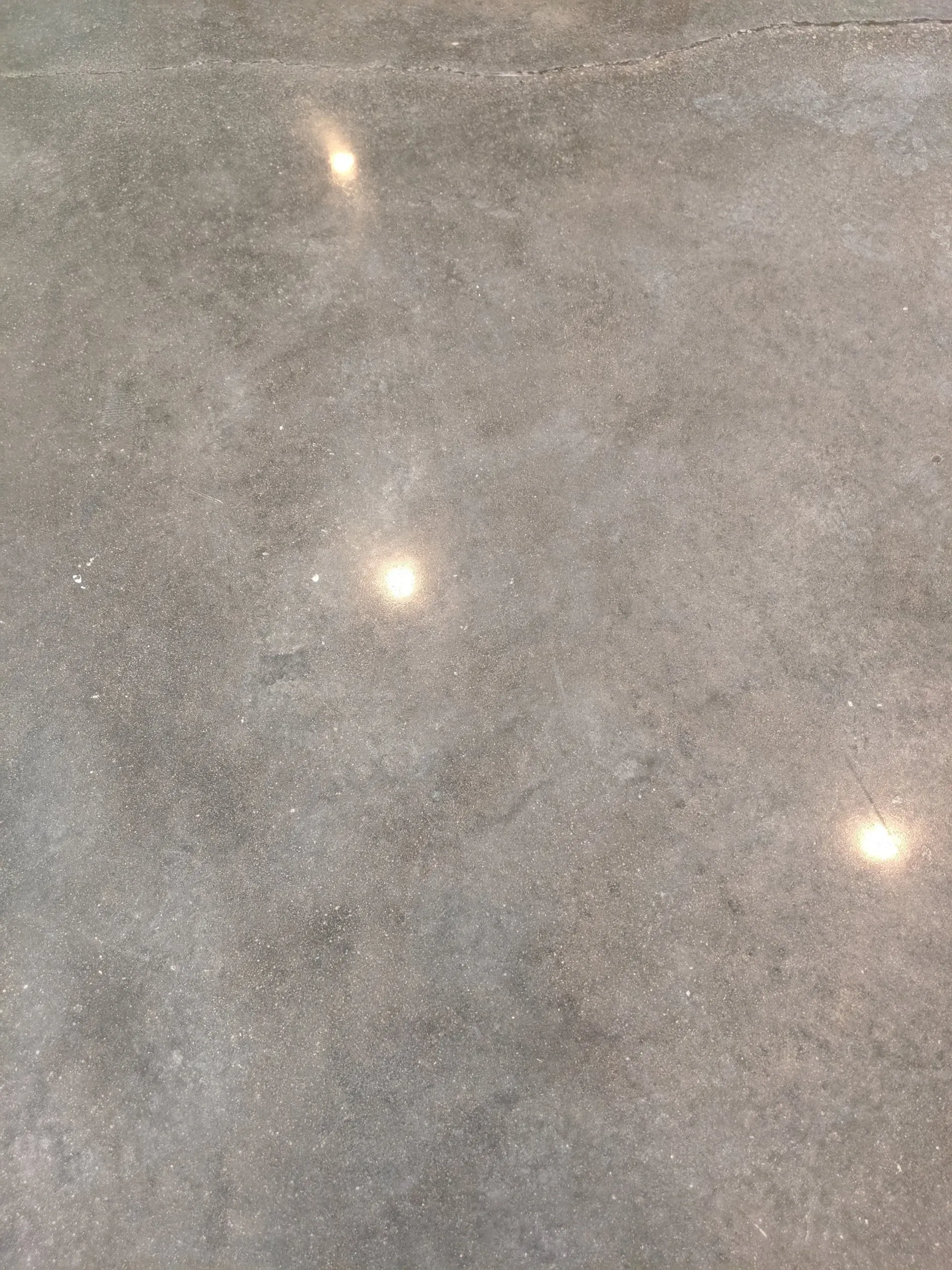Three bright reflections on a gray speckled stone surface
