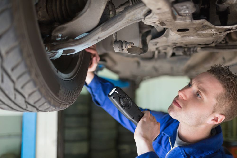 Mechanic Checking Car Wheels — Brake Specialists in Gold Coast