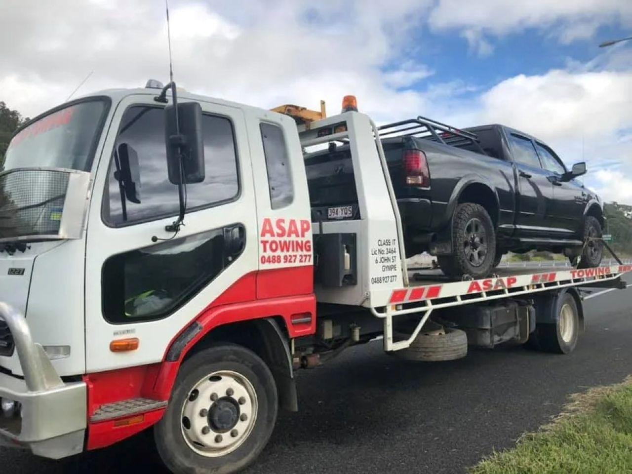 Tow Truck Carrying a Black Pickup Truck — ASAP Towing Pty Ltd In Gympie, QLD