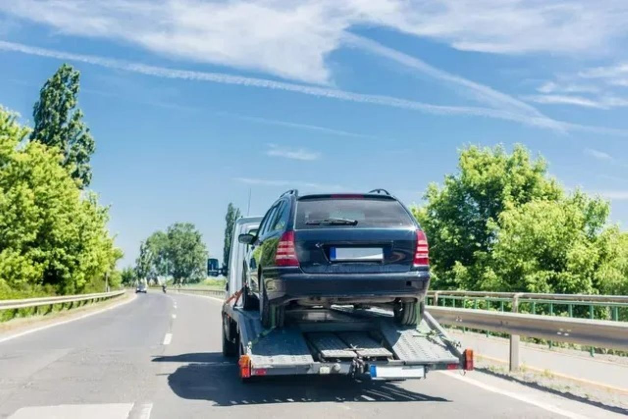 A Black Car Being Towed on a Flatbed Truck — ASAP Towing Pty Ltd In Gympie, QLD
