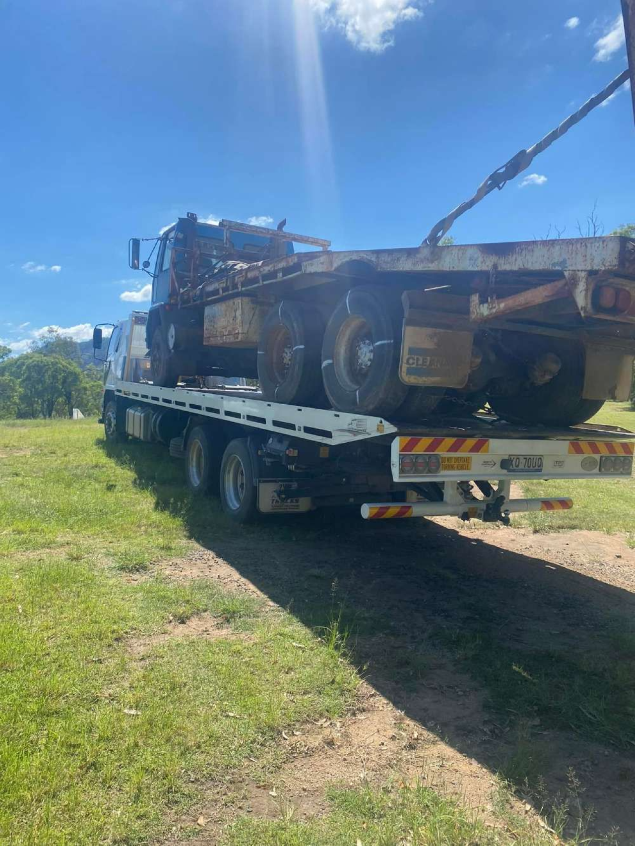 Flatbed Truck Carrying a Rusty, Burned-out Truck — ASAP Towing Pty Ltd In Cooroy, QLD
