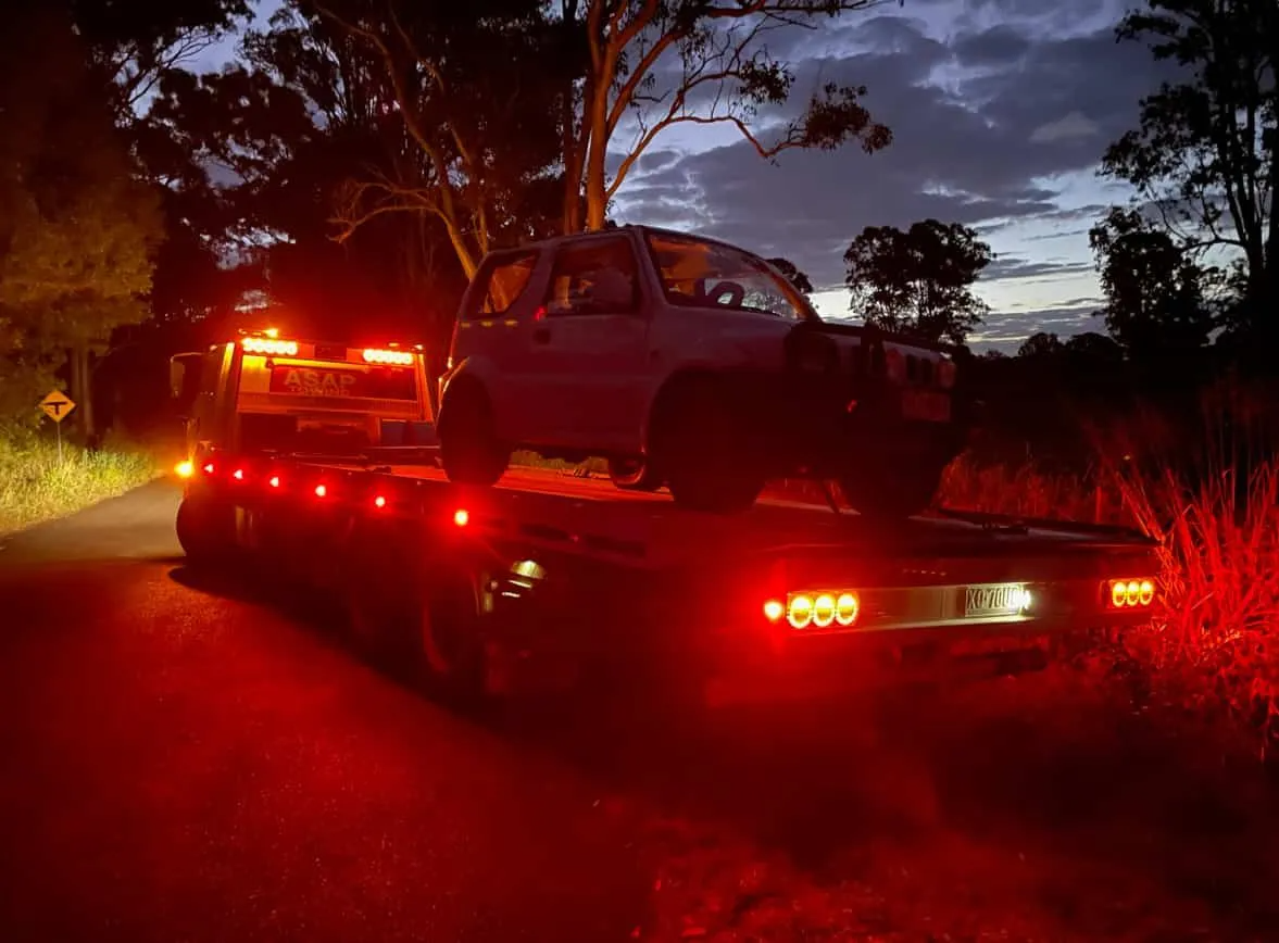 Tow truck with SUV on its flatbed at dusk — ASAP Towing Pty Ltd In Rainbow Beach, QLD