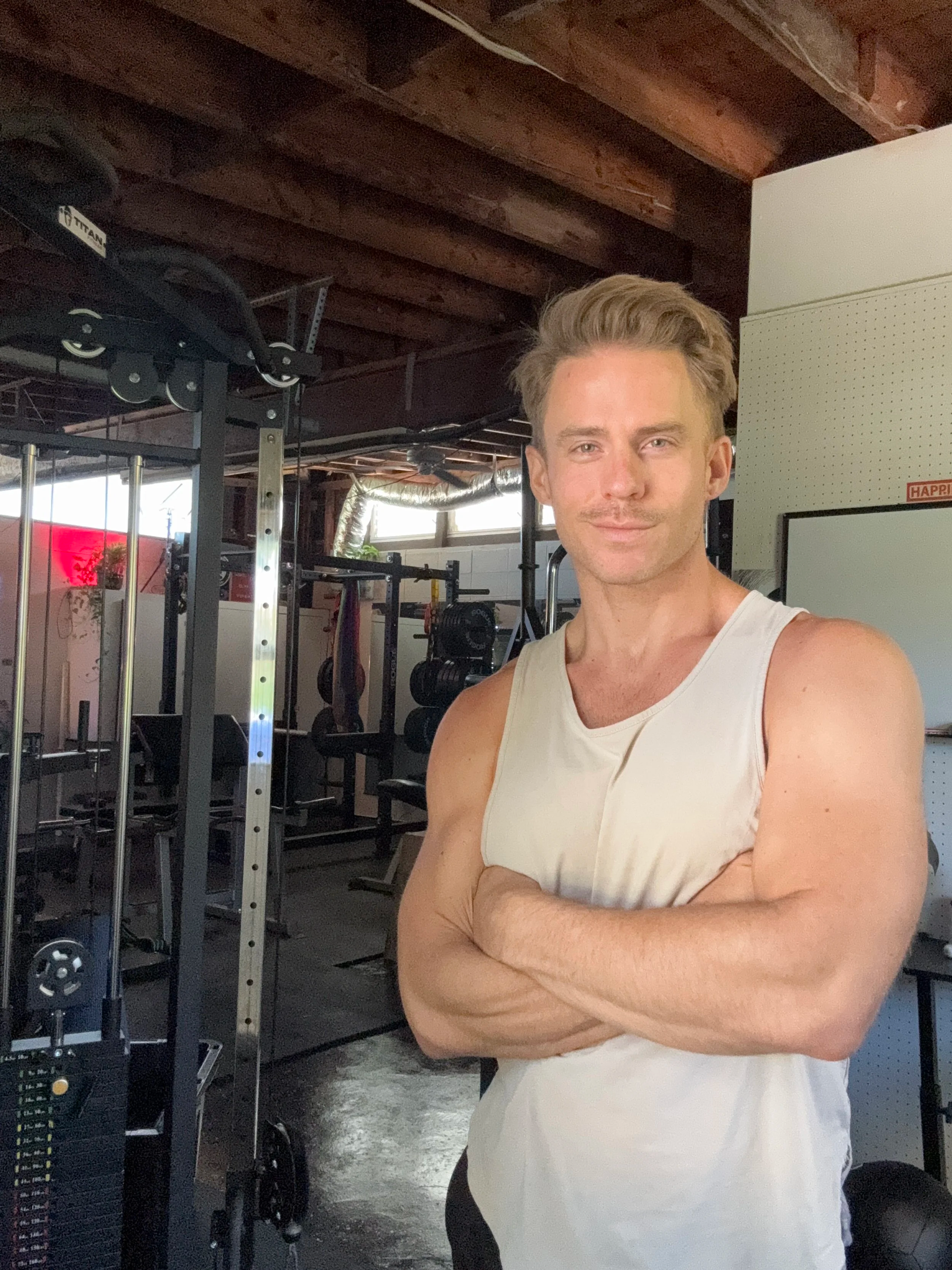 Woman doing core exercise with weight in gym, others working out in background.