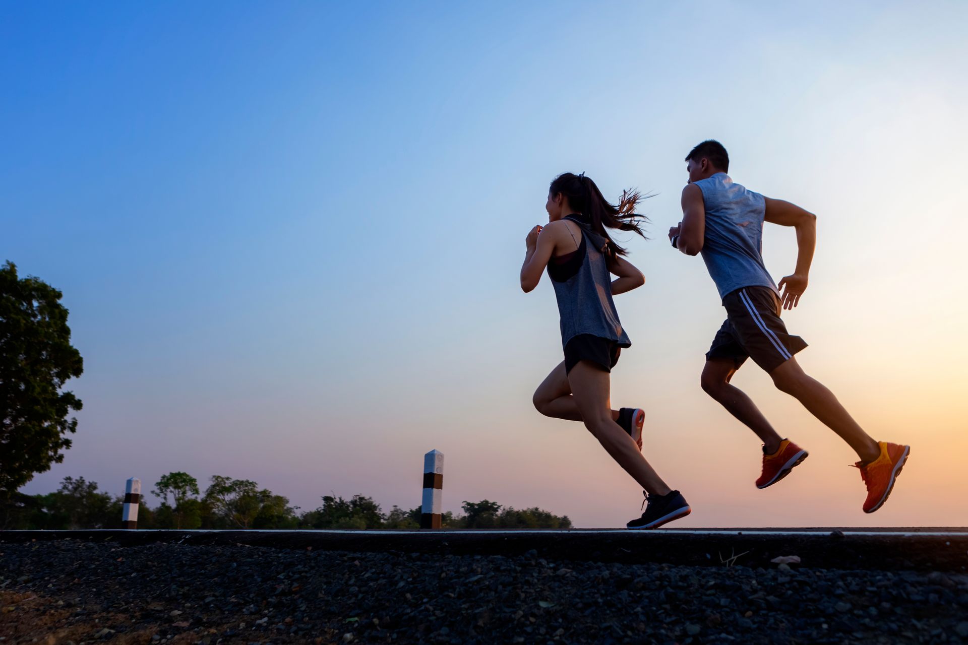 Two people running outdoors at dusk.