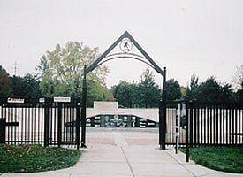 A fence surrounds a skate park with a ramp in the background