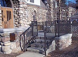 A stone building with stairs leading up to it and a metal railing.