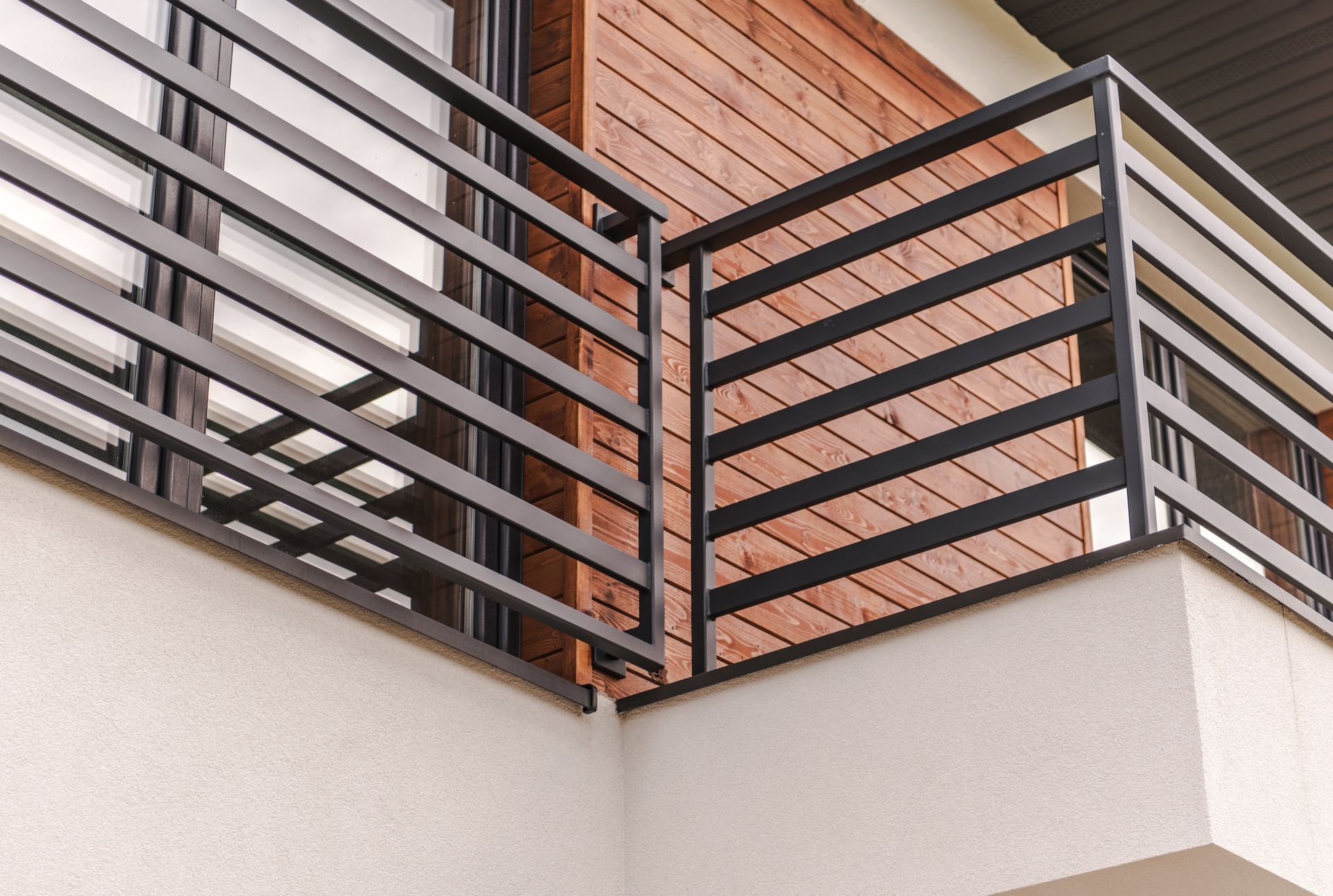 A balcony with a metal railing on the side of a building.