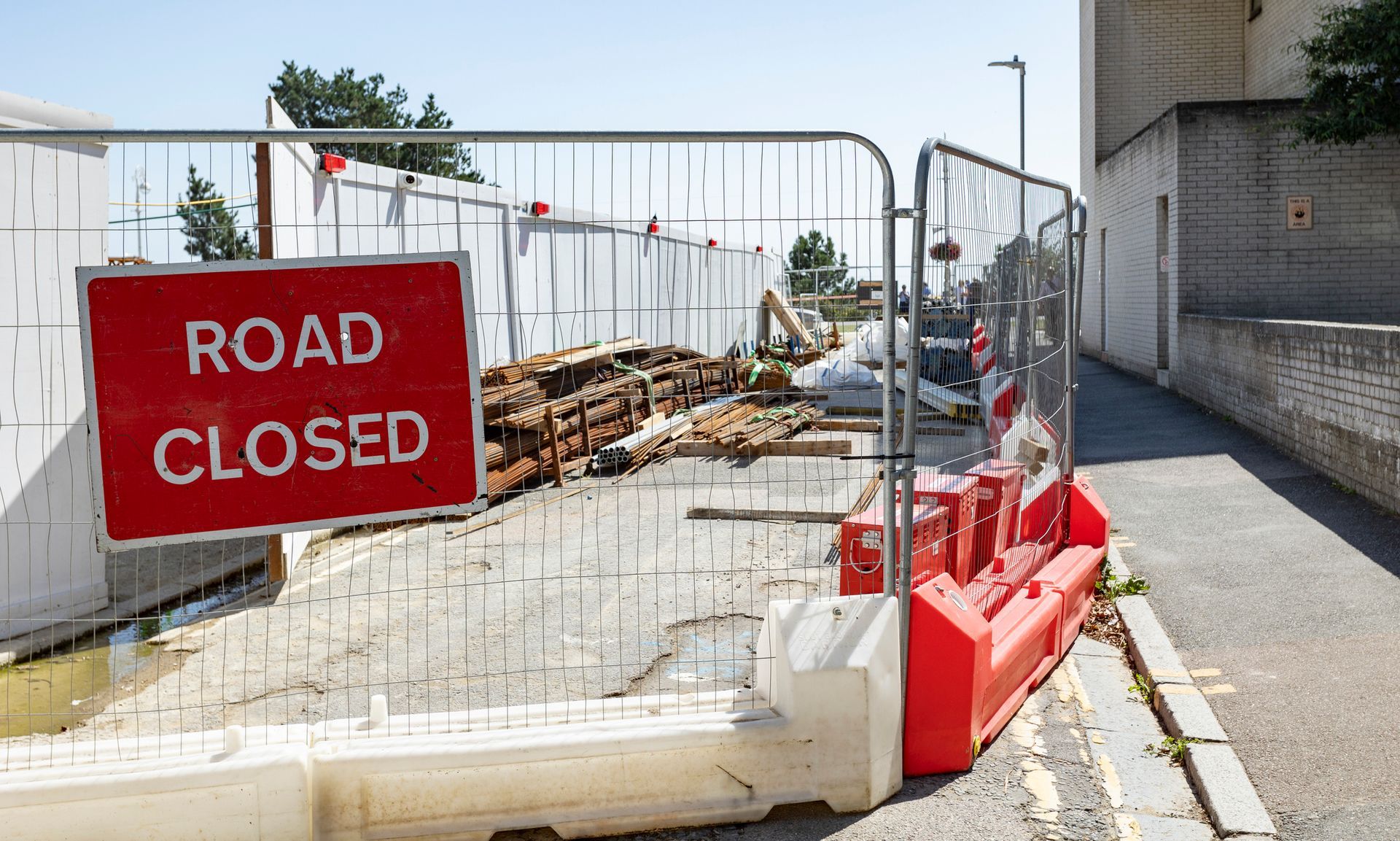 A stack of metal barriers on a brick sidewalk.
