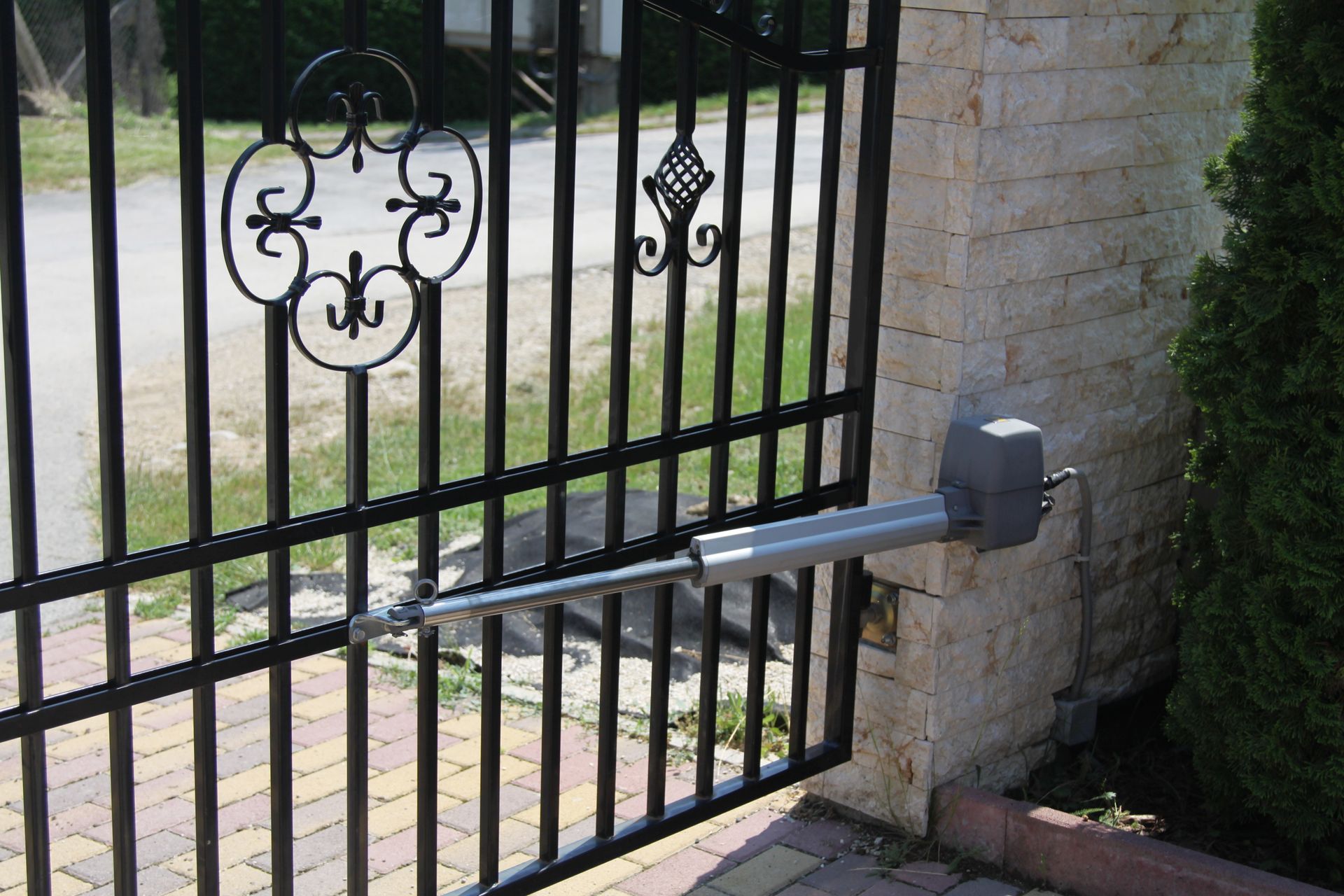 A wrought iron gate with a motor attached to it