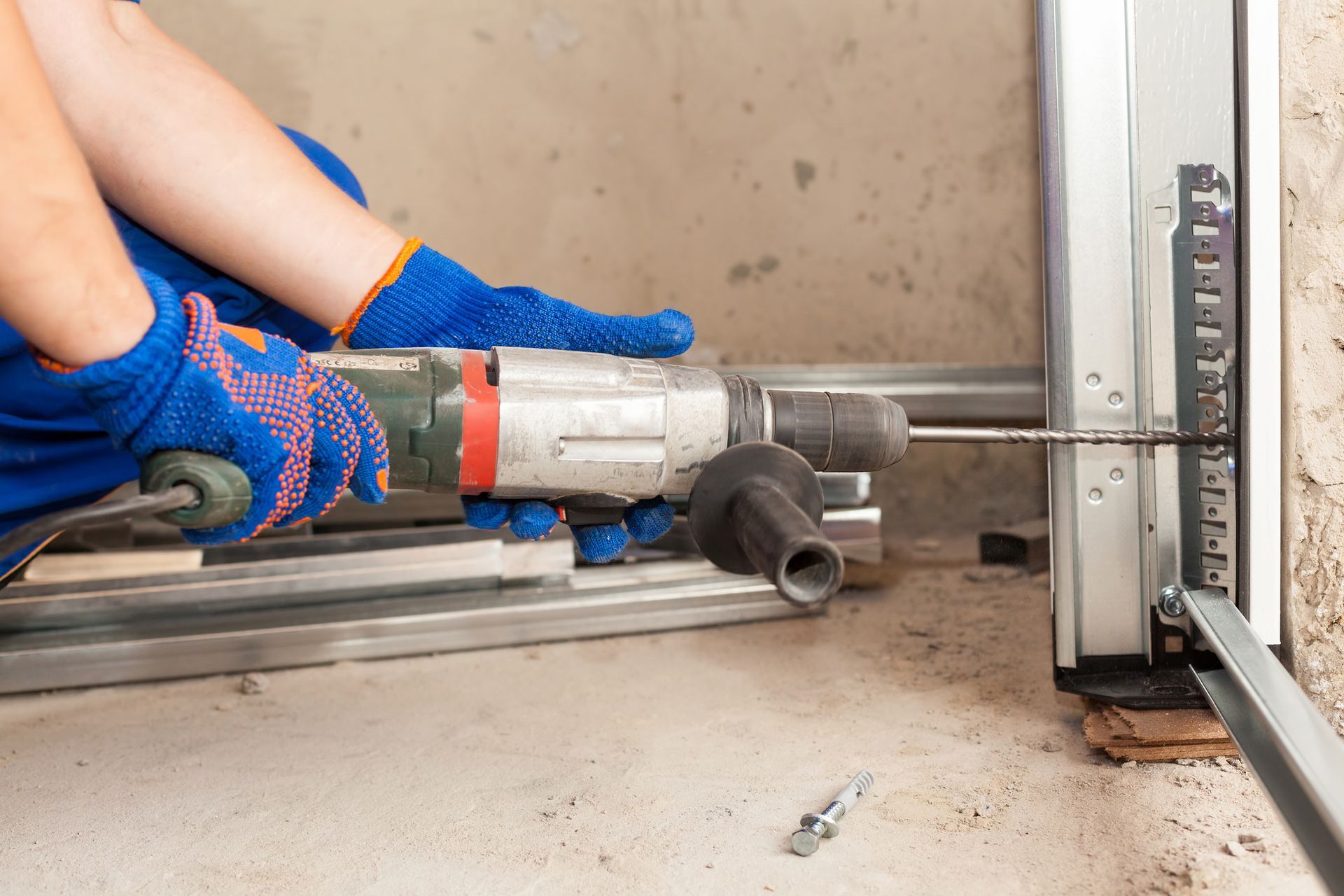 A person is using a drill to install a garage door.