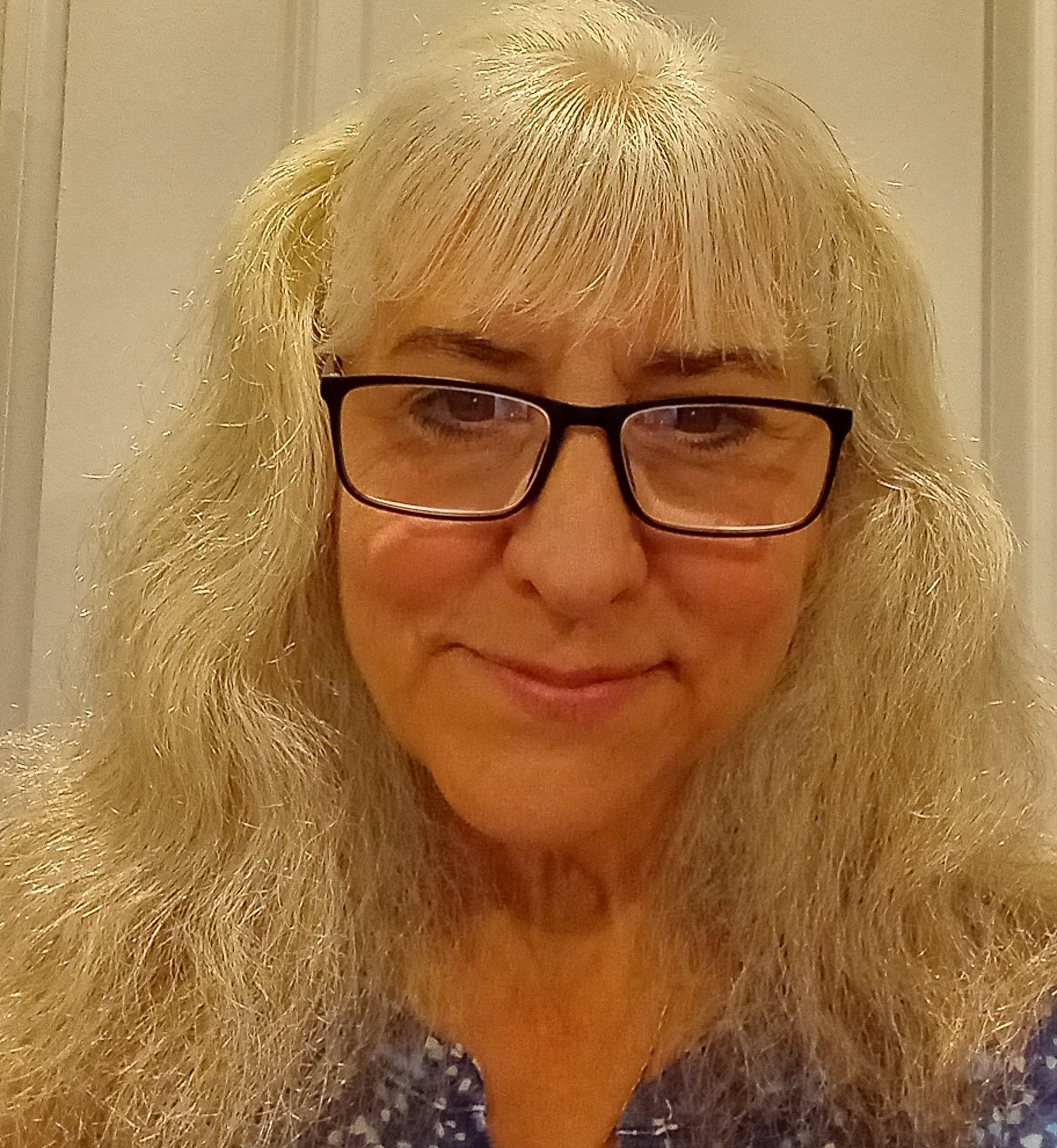 A sandy beach with waves crashing against the shore on a cloudy day.