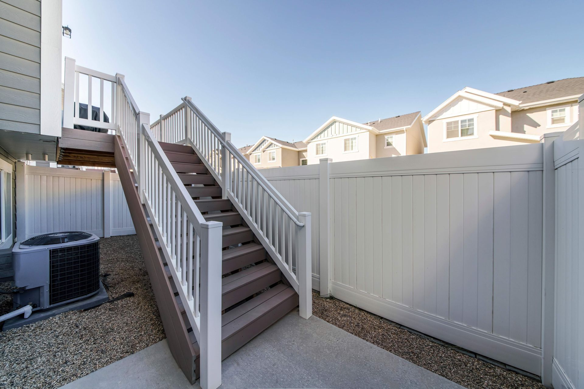 a set of stairs leading up to a deck next to a white fence .