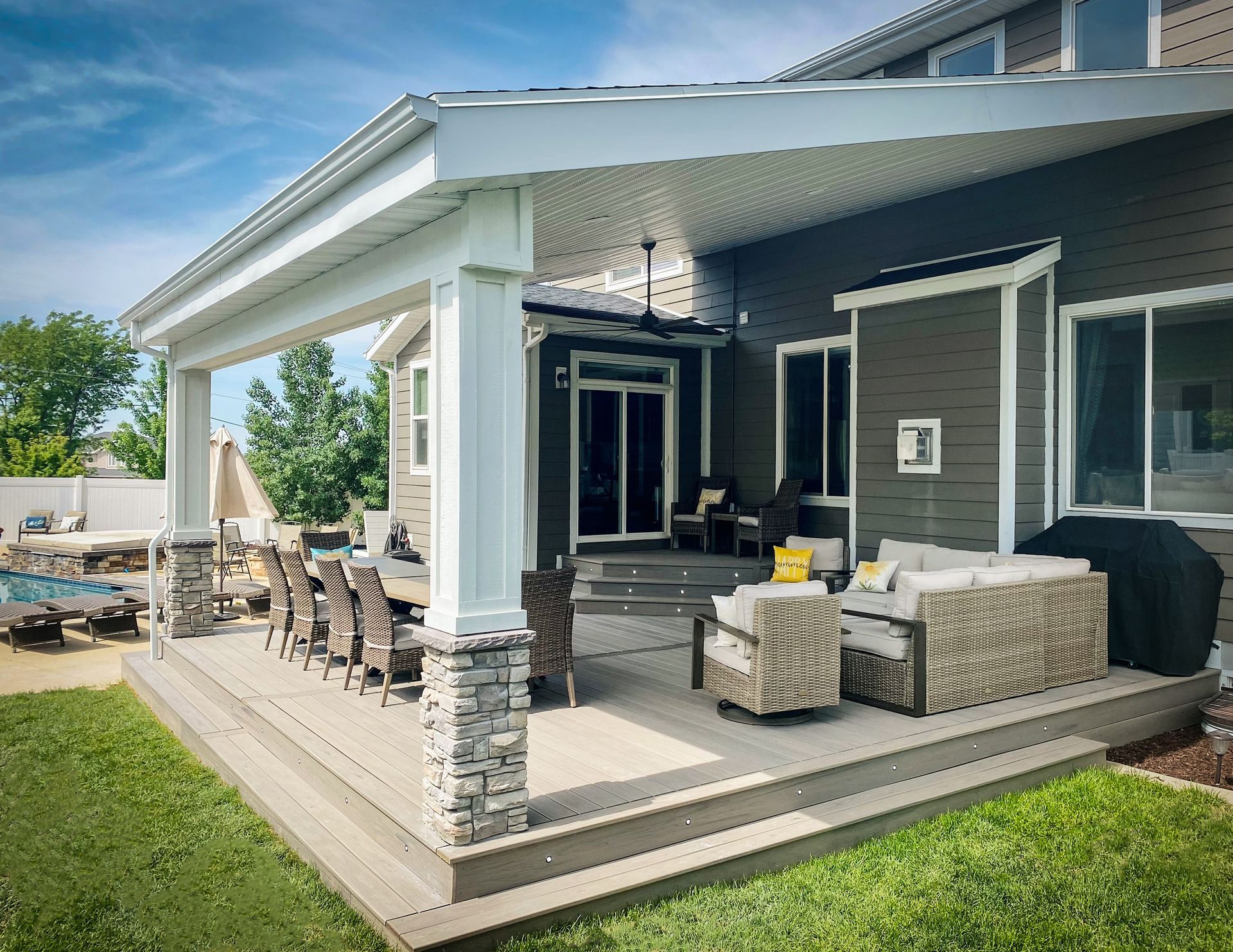 a large covered patio with a table and chairs under a ceiling fan .