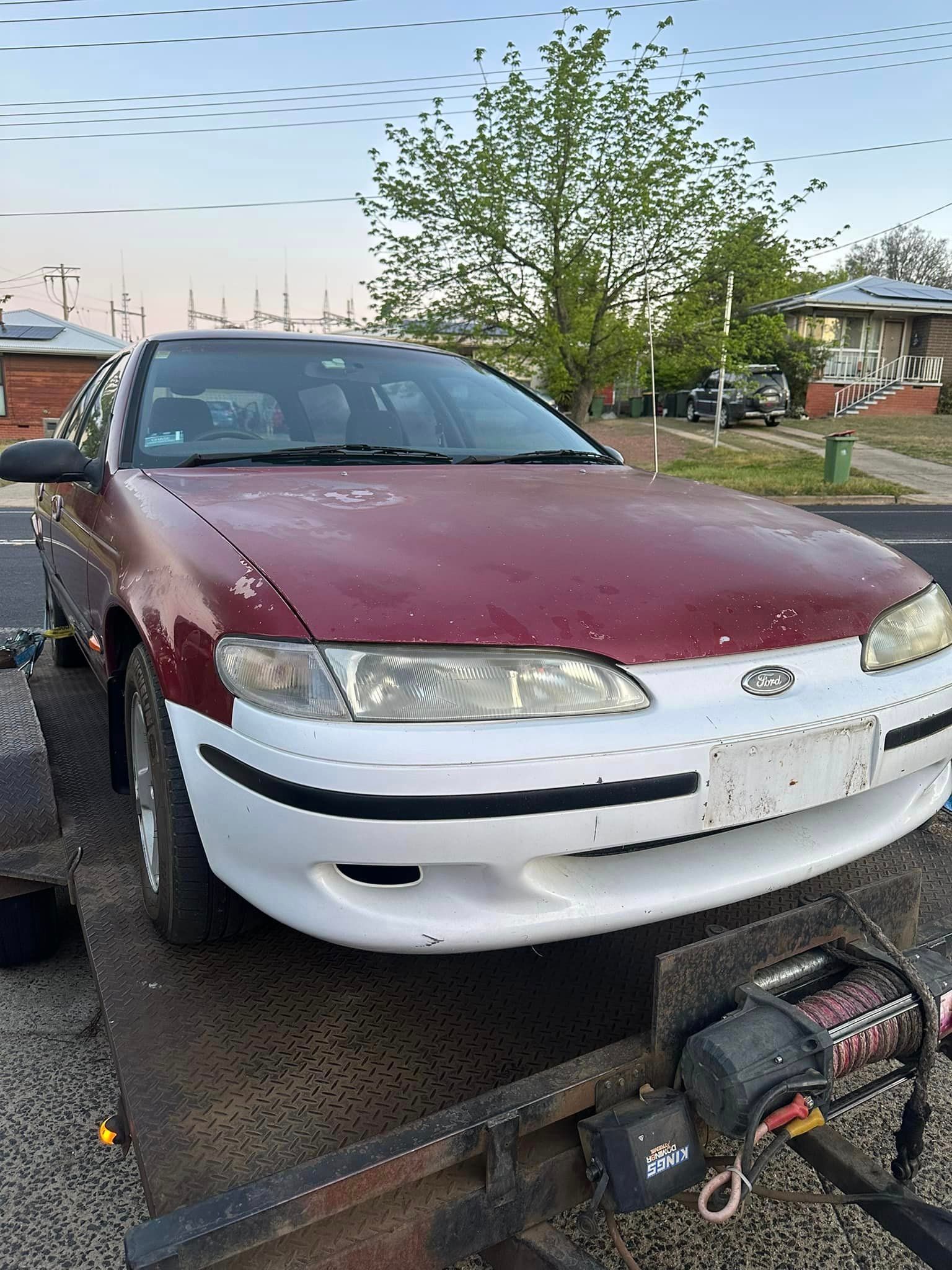 A Red Car Is Sitting On Top Of A Trailer — R N R Wrecking N Scrap Car Removal In Beard, ACT