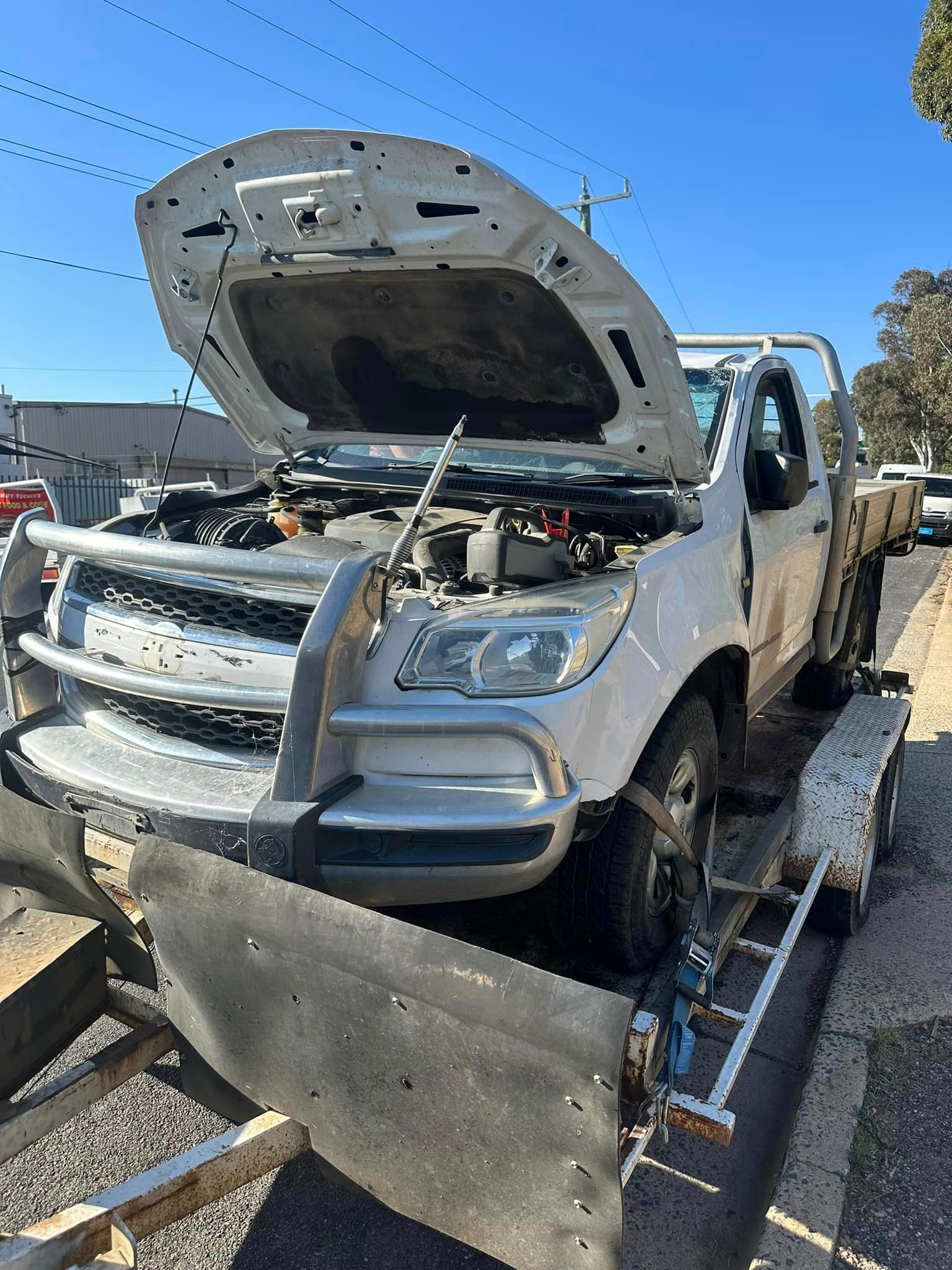 A White Truck With Its Hood Up Is On A Trailer — R N R Wrecking N Scrap Car Removal In Beard, ACT