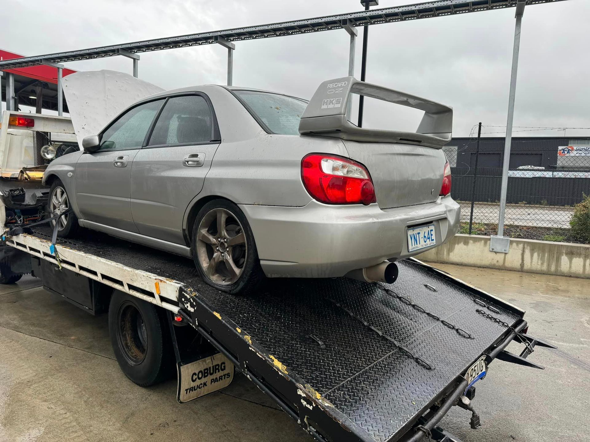A Red Car Is Being Towed By A Tow Truck — R N R Wrecking N Scrap Car Removal In Beard, ACT